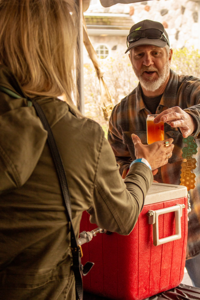 man handing over sample of beer